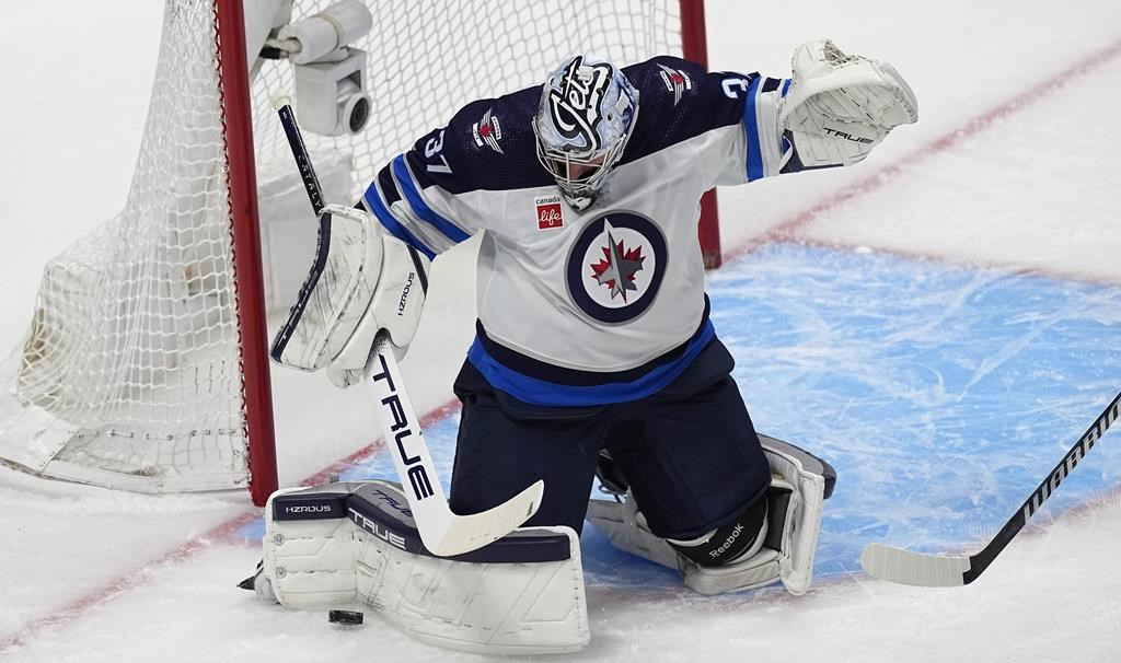 Winnipeg Jets goaltender Connor Hellebuyck makes a pad-save in the first period of Game 4 of an NHL Stanley Cup first-round playoff series against the Colorado Avalanche, Sunday, April 28, 2024, in Denver. (AP Photo/David Zalubowski).