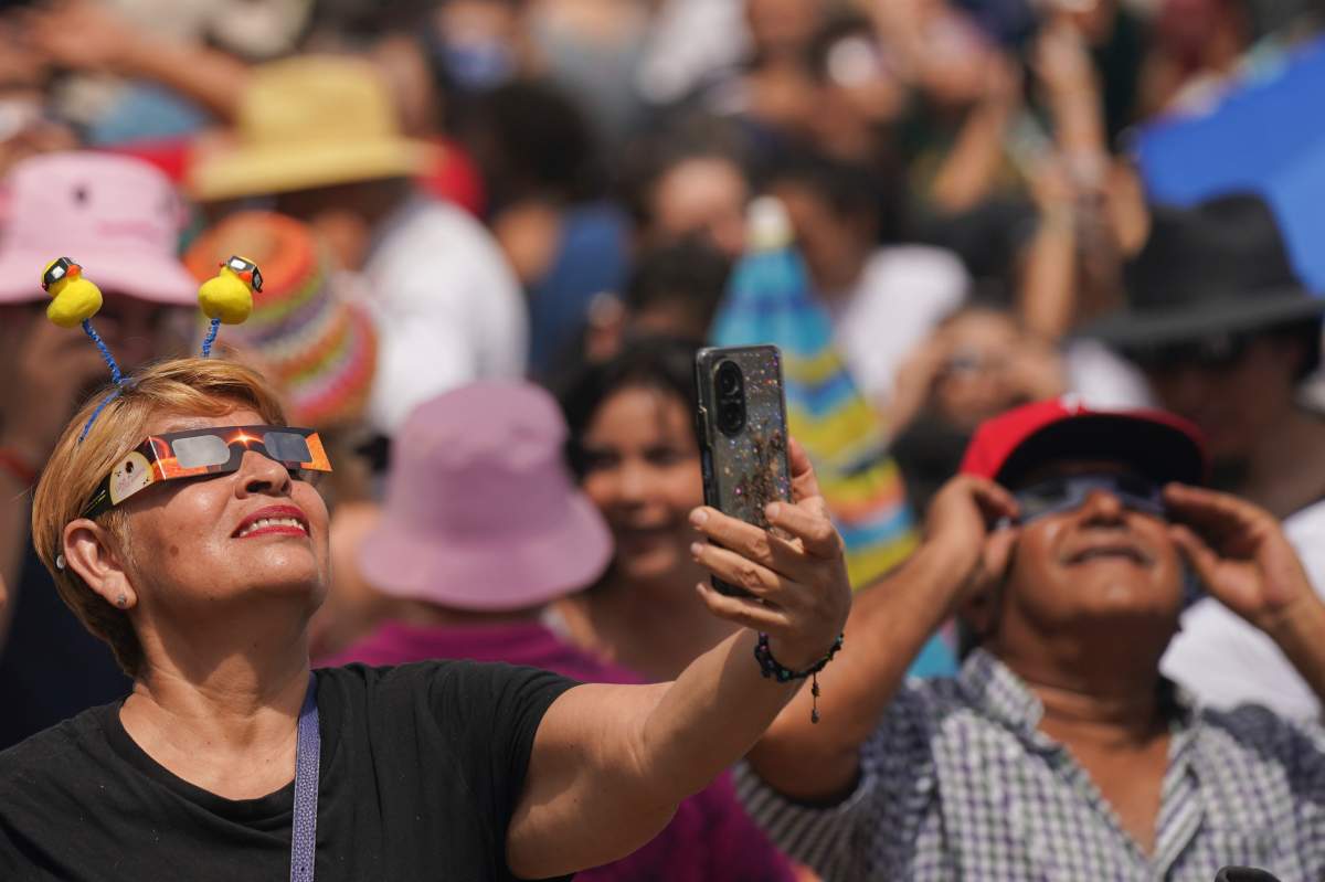 People use special glasses to watch a total solar eclipse in Mazatlan, Mexico, Monday, April 8, 2023. (AP Photo/Fernando Llano)