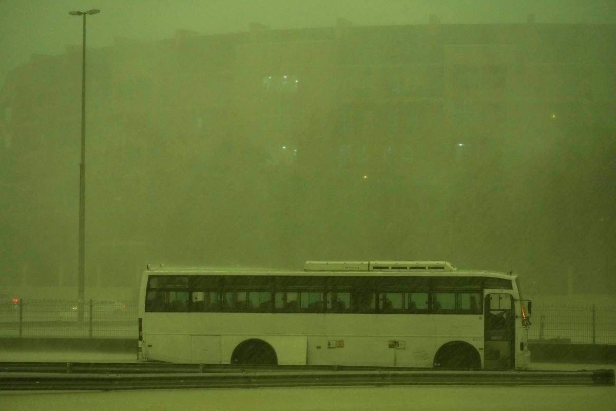 A bus stands abandoned in pouring rain as the sky turned green as a storm hit in Dubai, United Arab Emirates, Tuesday, April 16, 2024. Heavy rains lashed the United Arab Emirates on Tuesday, flooding out portions of major highways and leaving vehicles abandoned on roadways across Dubai. Meanwhile, the death toll in separate heavy flooding in neighboring Oman rose to 18 with others still missing as the sultanate prepared for the storm. (AP Photo/Jon Gambrell)
