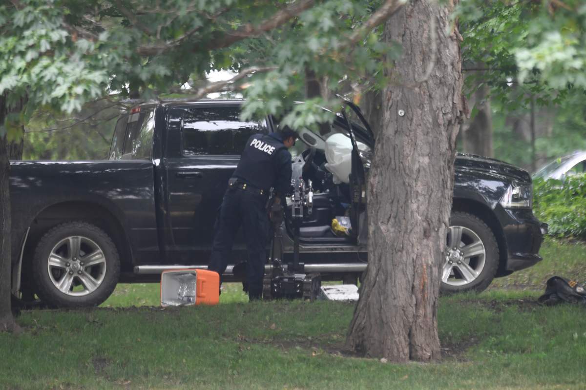 Police examine a pickup truck after Corey Hurren rammed the gates of Rideau Hall, July 2, 2020. THE CANADIAN PRESS/Adrian Wyld
