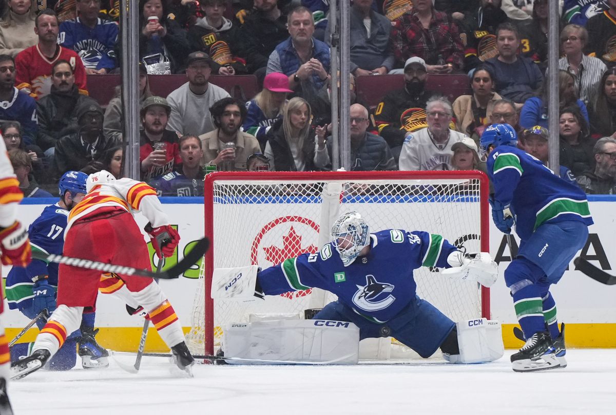 Vancouver Canucks goalie Thatcher Demko (35) stops Calgary Flames' Martin Pospisil, front left, during the second period of an NHL hockey game in Vancouver, on Tuesday, April 16, 2024.
