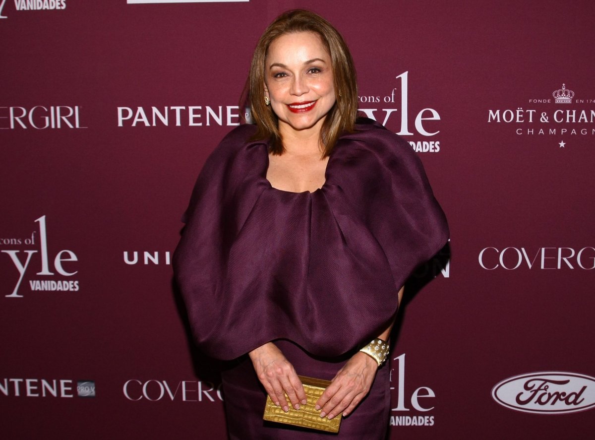 Nancy Gonzalez in a port wine coloured dress. She is carrying a small yellow clutch bag.
