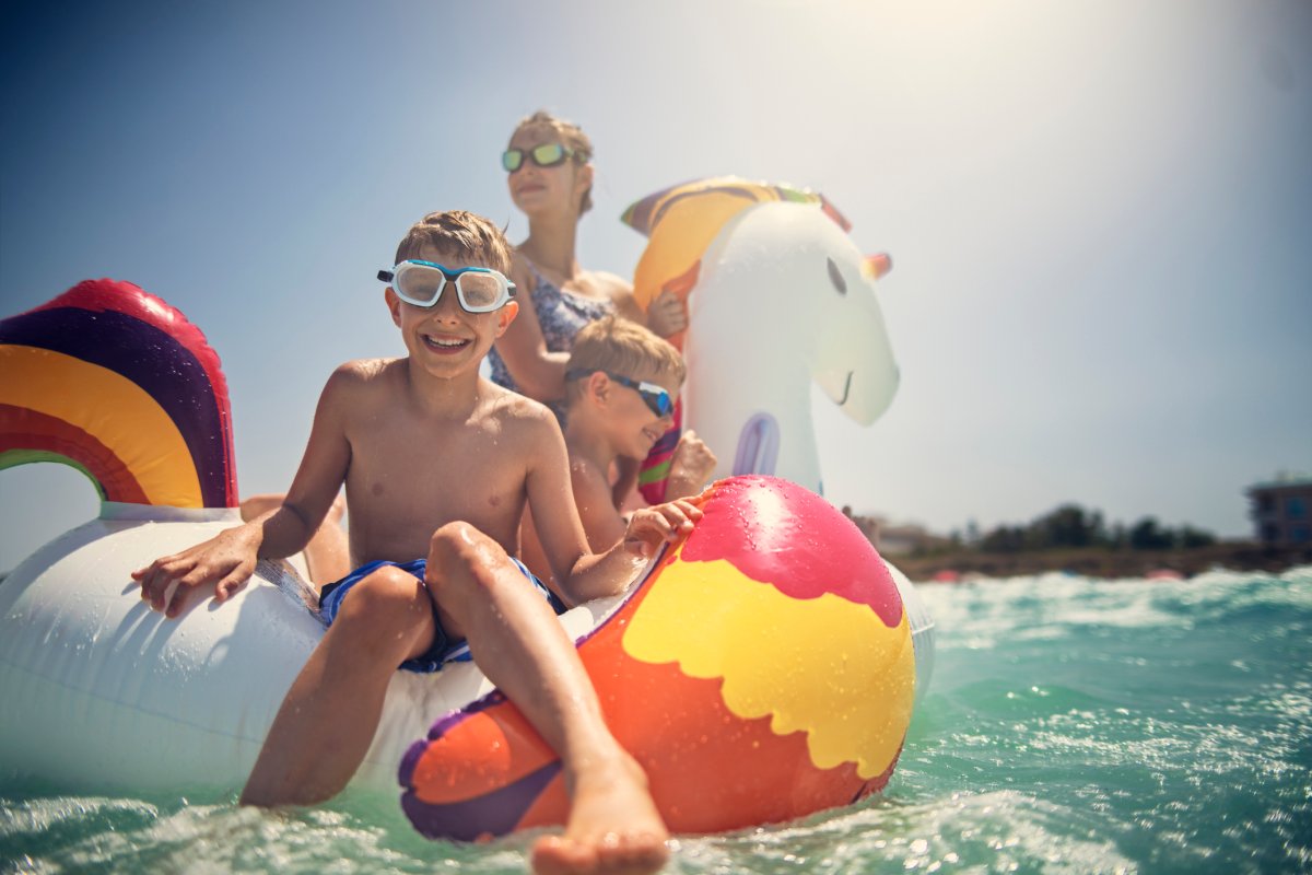 Kids are splashing and having fun on giant inflatable unicorn at an all-inclusive resort
