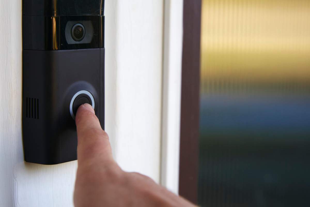 Close up POV shot of a person ringing a smart doorbell