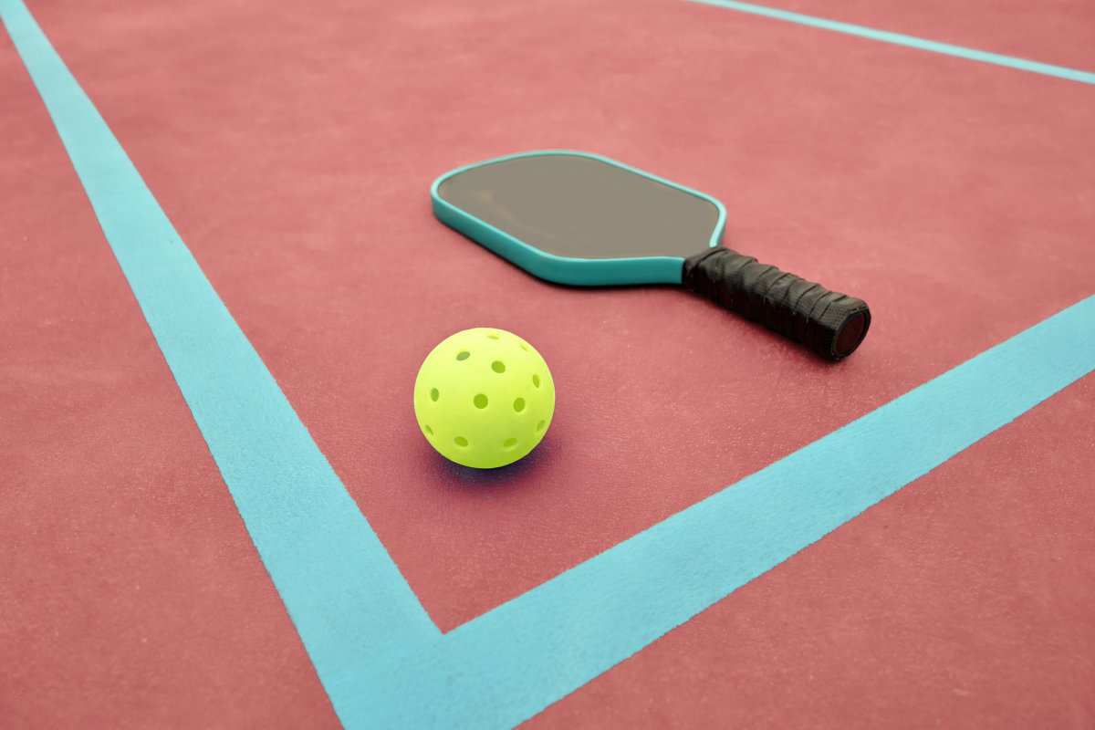 High angle view of pickleball paddle and ball on red pickle ball court