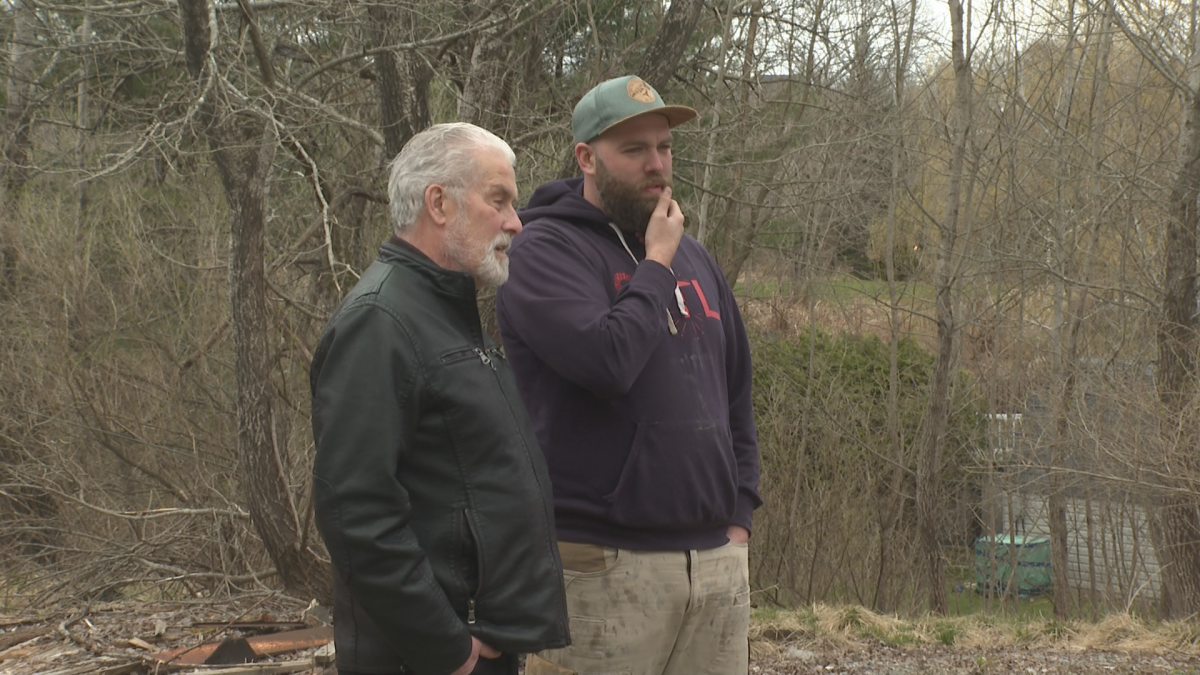 Graham Savage, left, and Brent Harris, right, discuss the initiative outside of one of the project’s potential homes on Wednesday morning.