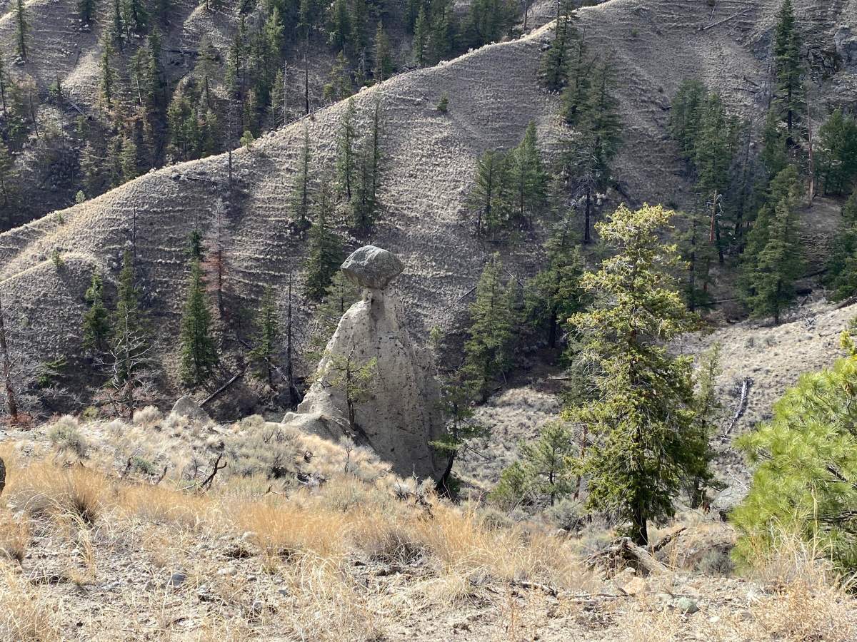 A smaller rock balances on top of a larger one.