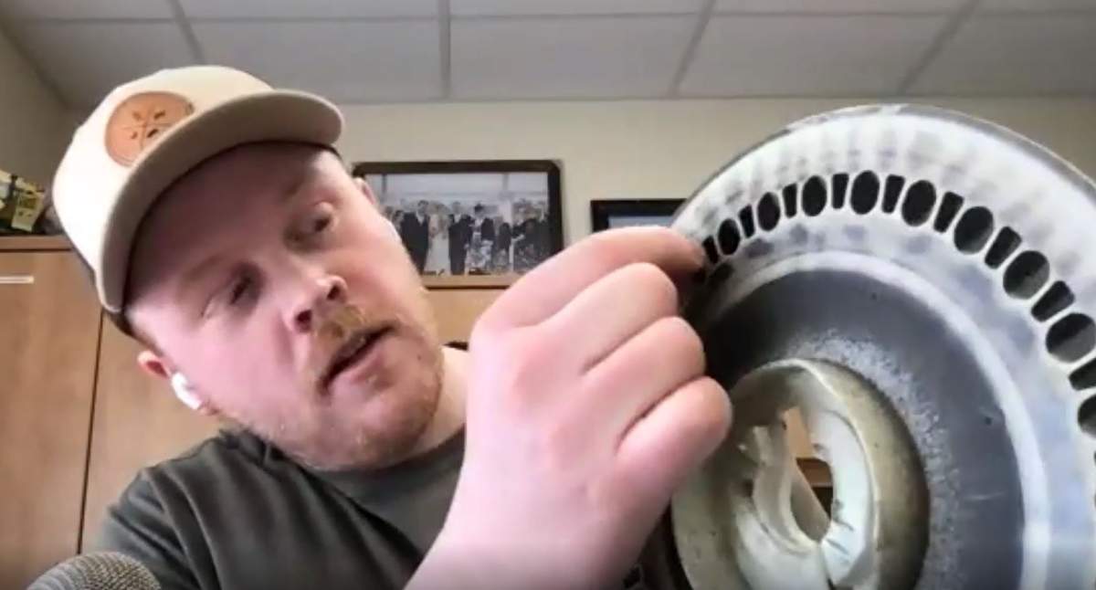 Jake Ayre puts a seed into a planter disc to demonstrate its function.