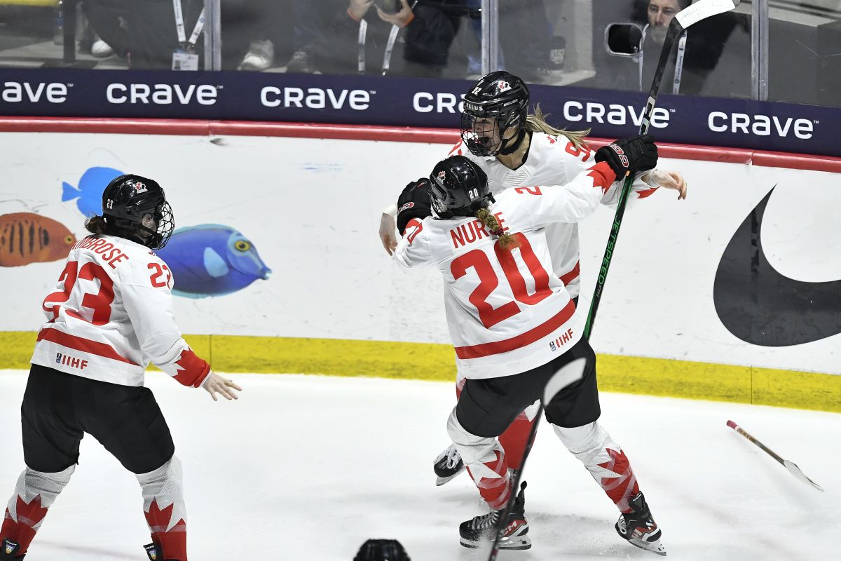Canada forward Danielle Serdachny, right, celebrates with forward Sarah Nurse (20) and defensewoman Erin Ambrose (23) after scoring the winning goal against the United States during overtime in the final at the women's world hockey championships in Utica, N.Y., Sunday, April 14, 2024.