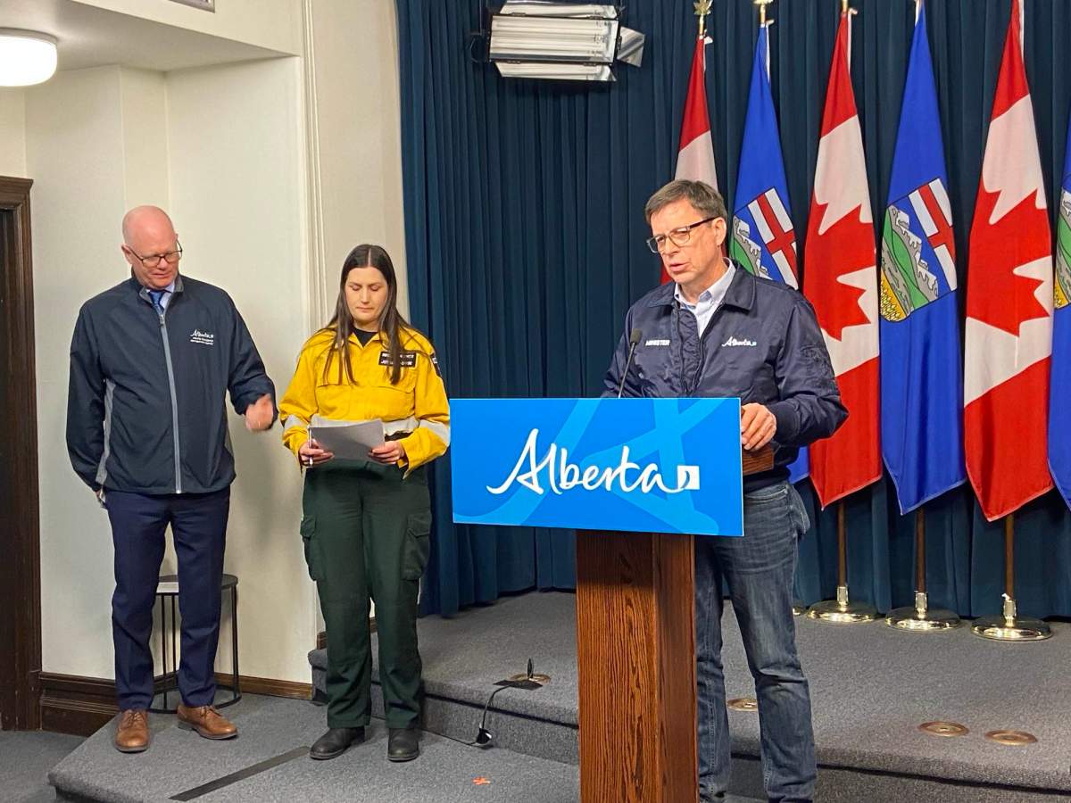 Forestry and Parks Minister Todd Loewen speaks to reporters at a news conference in Edmonton on April 24, 2024. Alberta Wildfire information officer Josee St. Onge and Stephen Lacroix, managing director of the AEMA, are also seen in this photo.