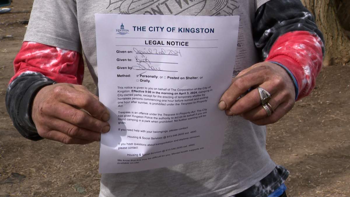 A resident of the Belle Park encampment holds up a notice from the city he received Tuesday.