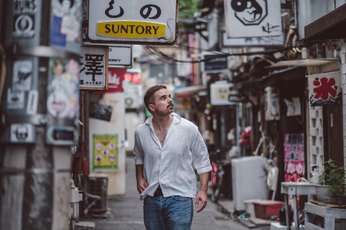Man walking in a street looking up