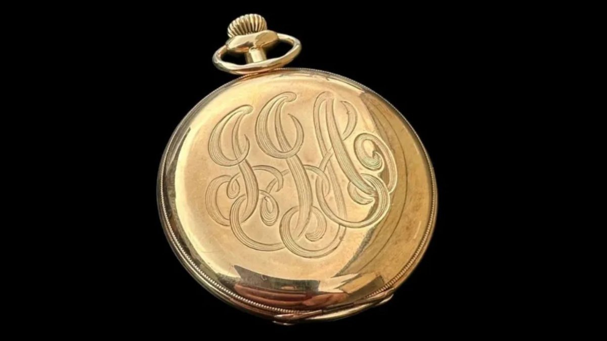 A gold pocket watch engraved with 'JJA.'