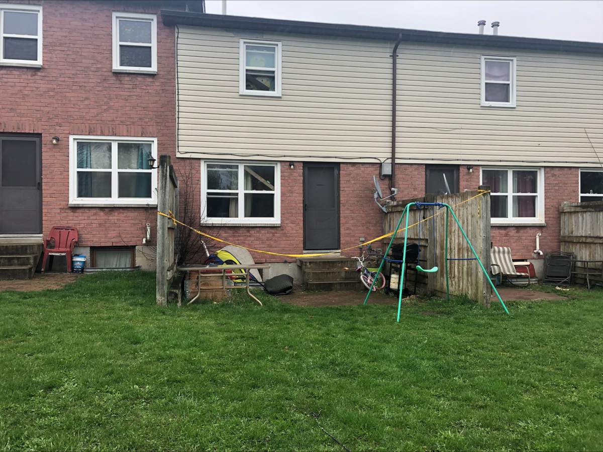 Police tape surround the rear of the residence on Alexandria Drive in Cobourg, Ont.