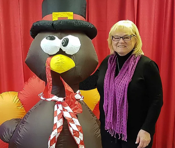 Sue Stultz posing with an inflatable turkey