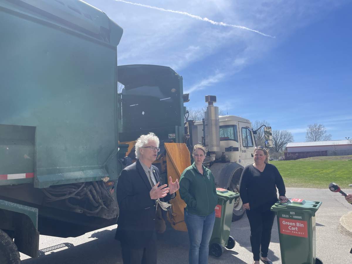 Jay Stanford (left), Elizabeth Peloza (middle) and Lisa Smith (right) in front of the pilot project green bins and the specialized garbage truck.