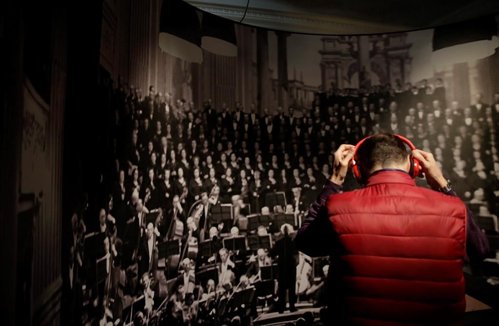 A researcher out of British Columbia's Simon Fraser University says the brains of older adults feel a sense of reward when listening to music, even if it's a song that they don't particularly like. A guest listens Arturo Toscanini's operas on a headphone during the unveiling of the exhibition on the Italian musician and composer, at La Scala opera theatre in Milan, Italy, Tuesday, March 21, 2017. THE CANADIAN PRESS/AP-Luca Bruno.