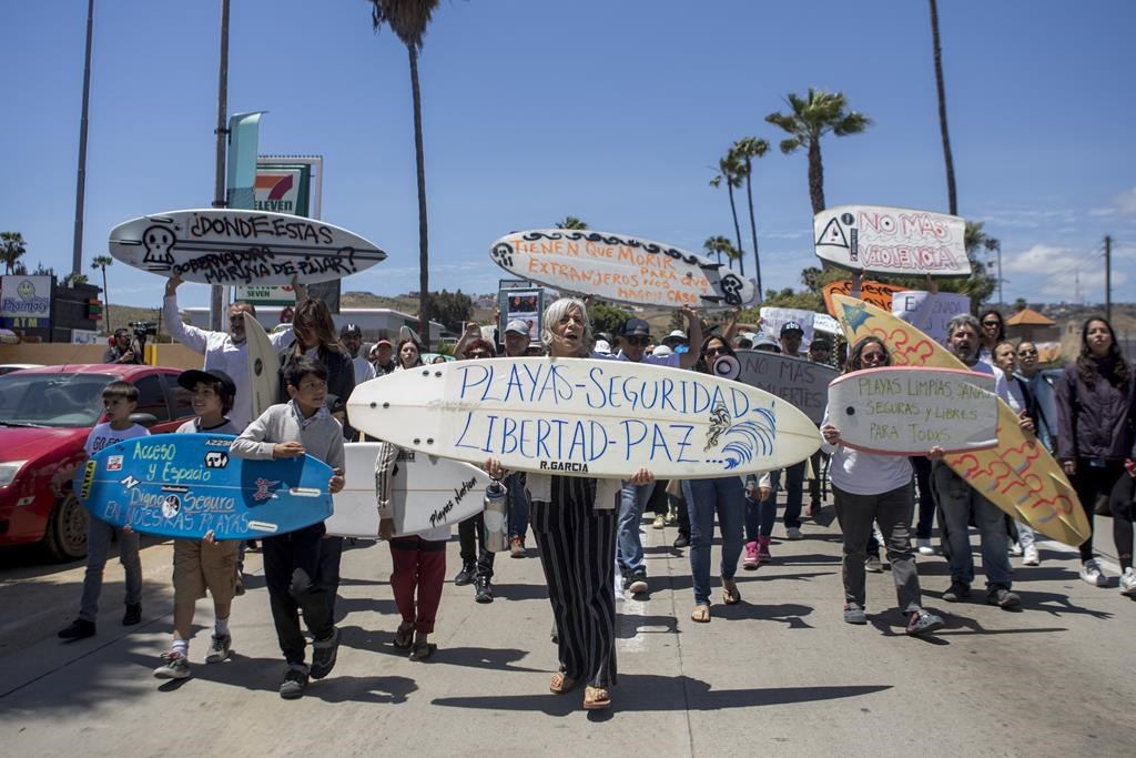 Locals march to protest the disappearance of foreign surfers in Ensenada, Mexico, Sunday, May 5, 2024. Mexican authorities said Friday that three bodies were recovered in an area of Baja California near where two Australians and an American went missing last weekend during an apparent camping and surfing trip.