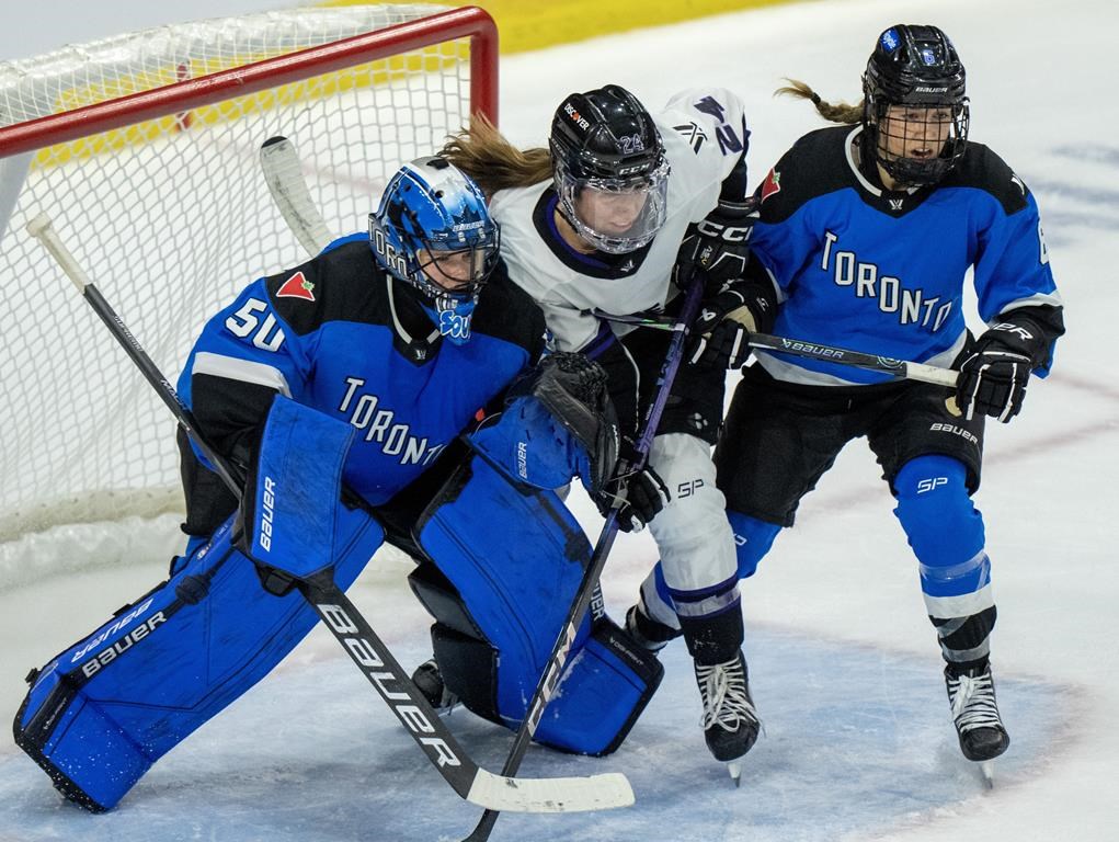 Toronto goaltender Kristen Campbell (50) battles for position with Minnesota's Abby Boreen (24) as Toronto Kali Flanagan (6) jumps in during second period PWHL playoff hockey action in Toronto on Friday, May 10, 2024.THE CANADIAN PRESS/Frank Gunn.