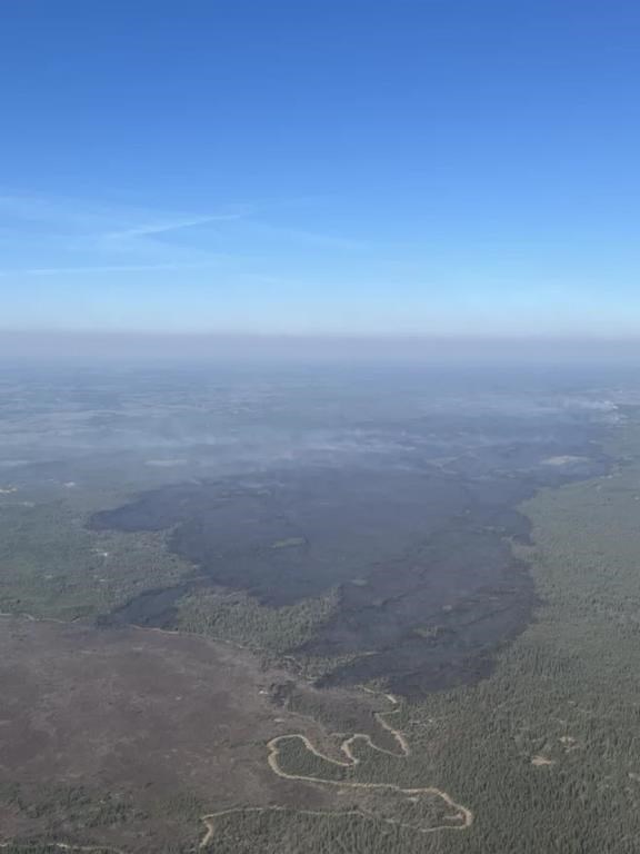 A massive swathe of burned forest is seen as a wildfire designated MWF017 by the Alberta Wildfire Service, top right, continues to burn near Ft. McMurray, Alta., in a Saturday, May 11, 2024, handout photo.