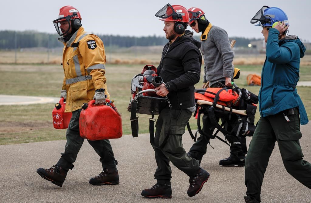 Wildfire crews on Sunday reported no further growth in the wildfire that continues to burn southwest of Fort McMurray, while Alberta Wildfire reports the same lack of growth allowed crews in the field to keep working on fireguards overnight. In this photo from Thursday, Alberta Wildfire crews return from fighting wildfires near Fort McMurray.