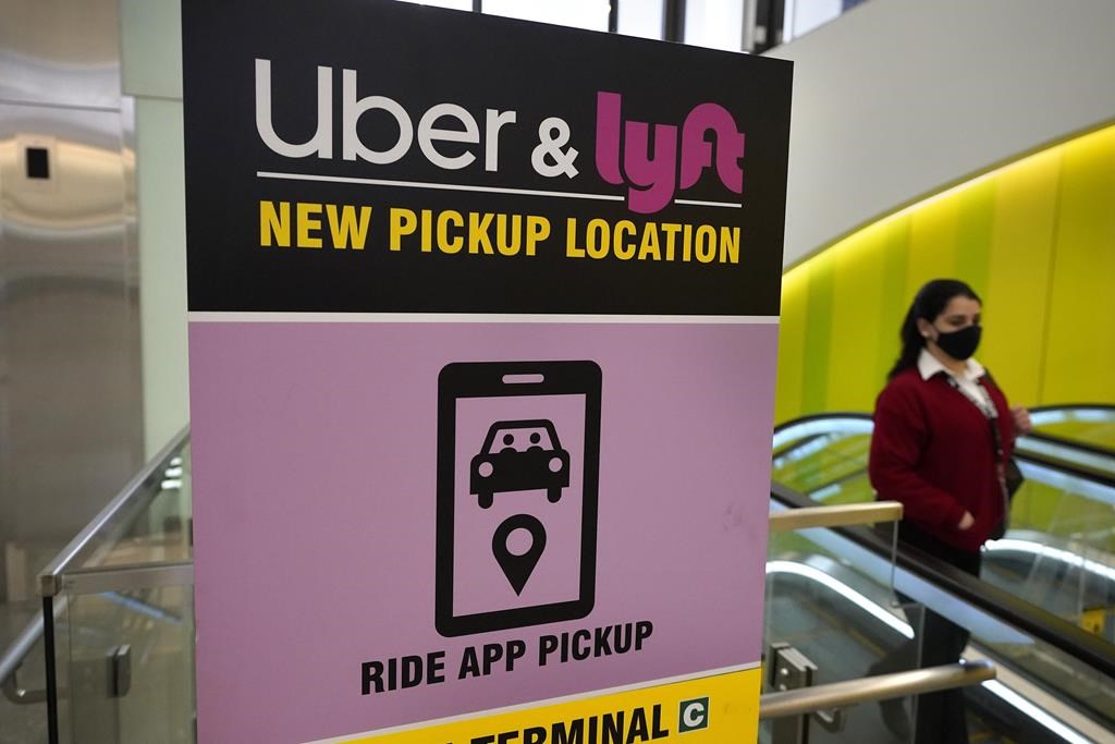 a sign offering directions to an Uber and Lyft ride pickup location at an airport.