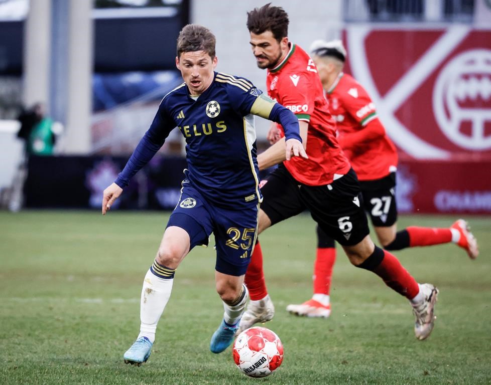 Vancouver Whitecaps FC midfielder Ryan Gauld, left, controls the ball as Cavalry FC midfielder Charlie Trafford chases him during second half soccer action in the Canadian Championship quarterfinal, leg 1, in Calgary, Tuesday, May 7, 2024.