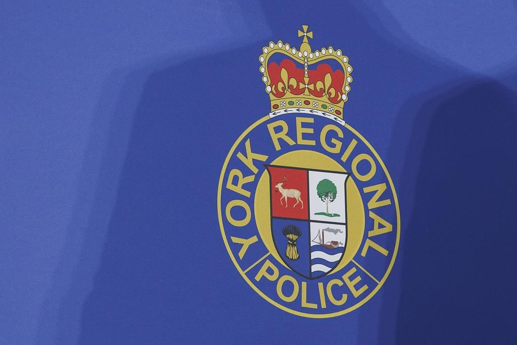 Police have charged a second man after a series of alleged shootings at at four movie theatres across the Greater Toronto Area. A shadow is cast over the logo of the York Regional Police during a press conference at their headquarters in Aurora, Ont., Wednesday, Jan. 31, 2024. 