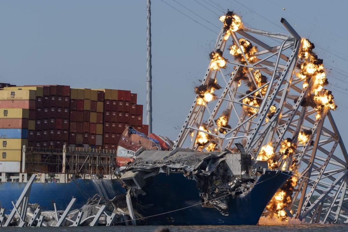 Explosive charges are detonated to bring down sections of the collapsed Francis Scott Key Bridge resting on the container ship Dali on Monday, May 13, 2024, in Baltimore. (AP Photo/Mark Schiefelbein)