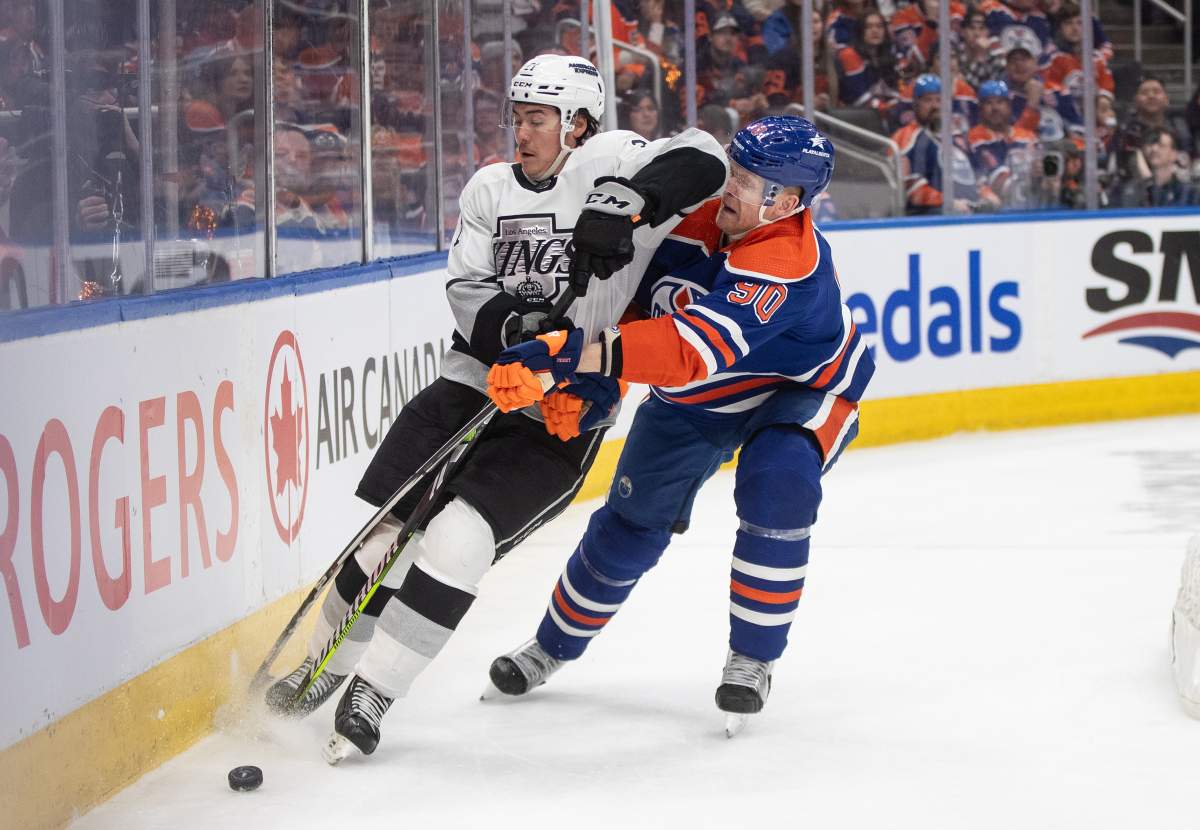 Los Angeles Kings' Jordan Spence (21) and Edmonton Oilers' Corey Perry (90) battle for the puck during second period NHL playoff action in Edmonton on Wednesday May 1, 2024.
