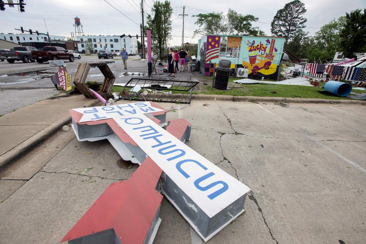 Employees gather at SusieQ Malt Shop to examine the remains of the longtime town hamburger stand on 2nd Street Sunday, May 26, 2024, in Rogers, Ark. The building was destroyed by a tornado Saturday night. (J.T. Wampler/The Northwest Arkansas Democrat-Gazette via AP)