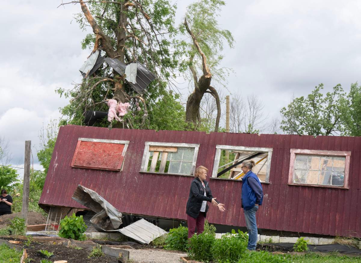 Julia Asselstine, right, surveys the damage to her property in Tres-Saint-Redempteur, Quebec on Tuesday, May 28, 2024 after a suspected tornado went through yesterday evening.