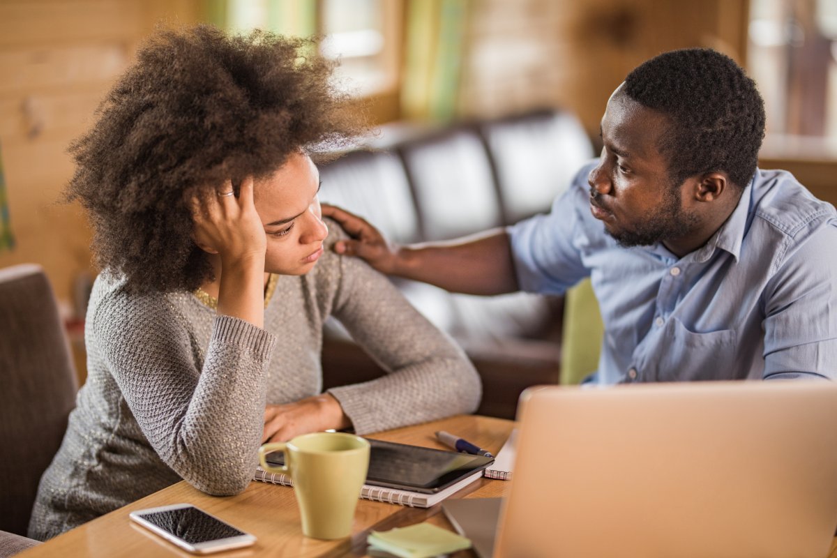 Young man consoling his worried girlfriend after finding out she has been Denied long-term disability for schizophrenia