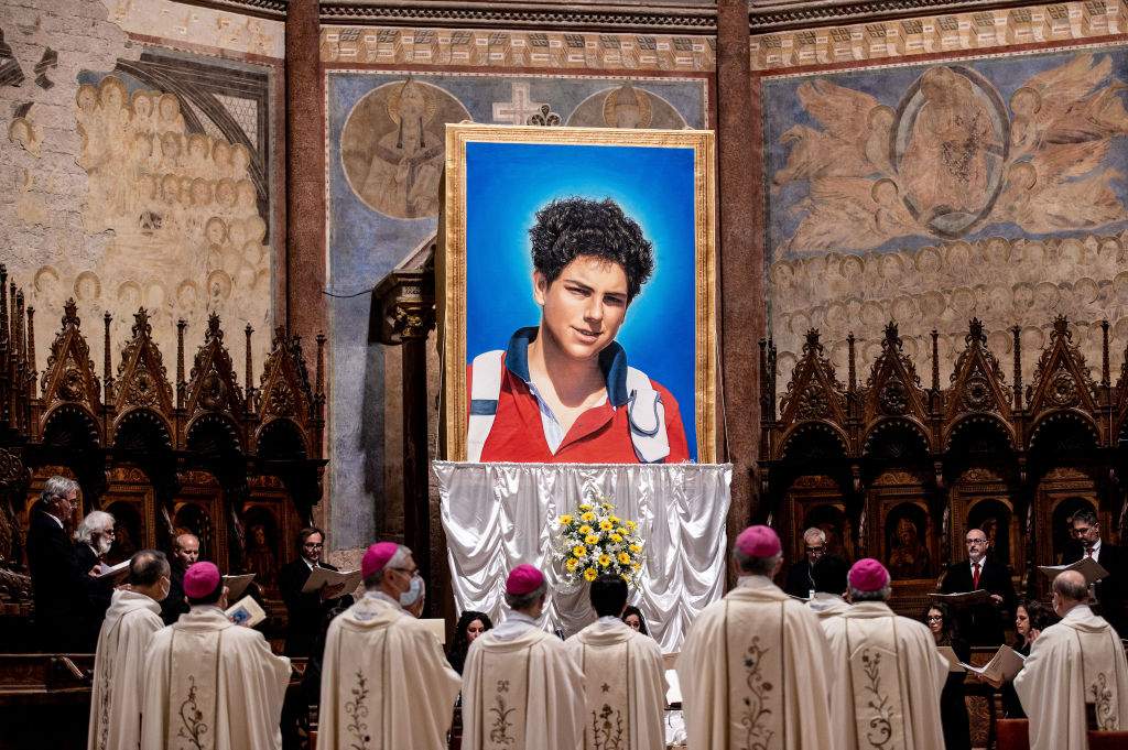 A tapestry featuring a portrait of Carlo Acutis hangs at the St. Francis Basilica during his beatification ceremony on October 10, 2020.