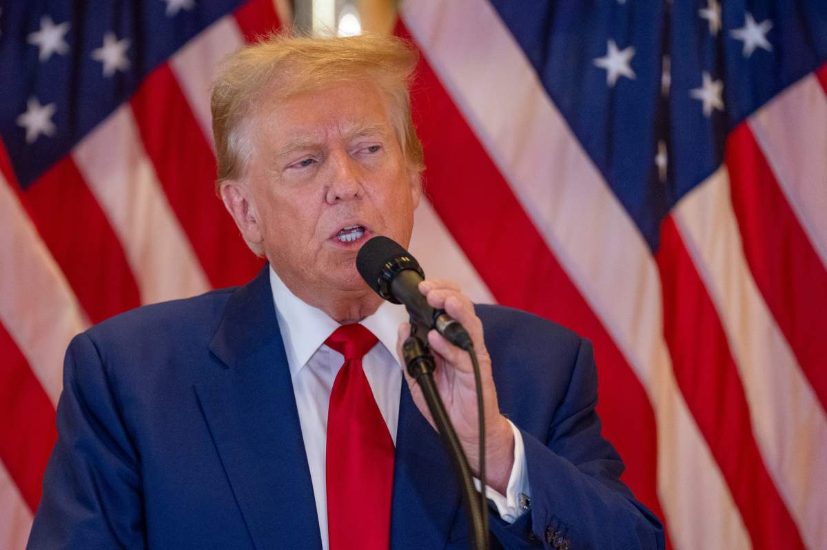 Donald Trump in front of American flags.