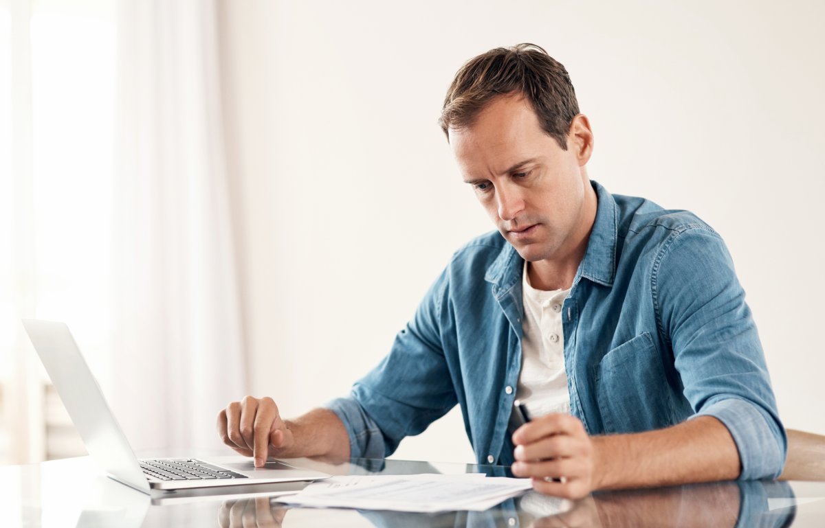 A young man working options on documents after being denied long-term disability for lupus