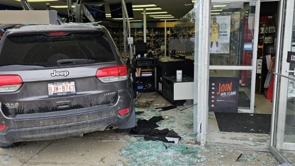 A black SUV drove through a liquor store in a strip mall.