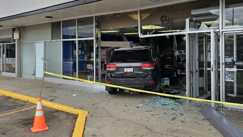 A black SUV drove through a liquor store in a strip mall.