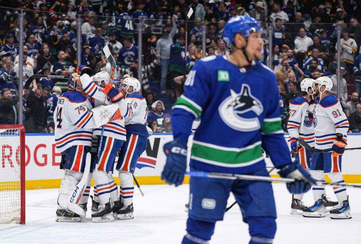 Edmonton Oilers goalie Stuart Skinner, back left, and his teammates celebrate as Vancouver Canucks' Dakota Joshua, front, looks on after Edmonton defeated Vancouver during Game 7 of an NHL hockey Stanley Cup second-round playoff series, in Vancouver, on Monday, May 20, 2024.