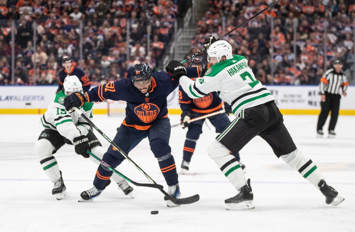 Dallas Stars' Craig Smith (left) and Jani Hakanpaa (right) battle for the puck with Edmonton Oilers' Evander Kane (91) during second period NHL action in Edmonton on Thursday November 2, 2023.
