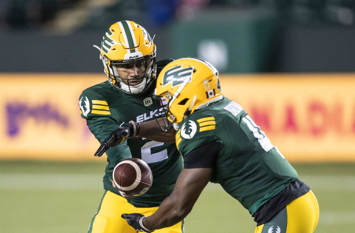 Edmonton Elks quarterback Tre Ford (2) hands off to Kevin Brown (4) against the B.C. Lions during first half CFL action in Edmonton, Alta., on Friday October 21, 2022.