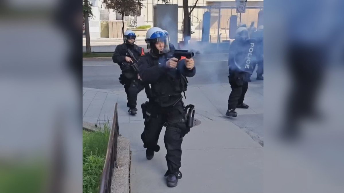 Police in riot gear seen shooting tear gas towards protesters.  