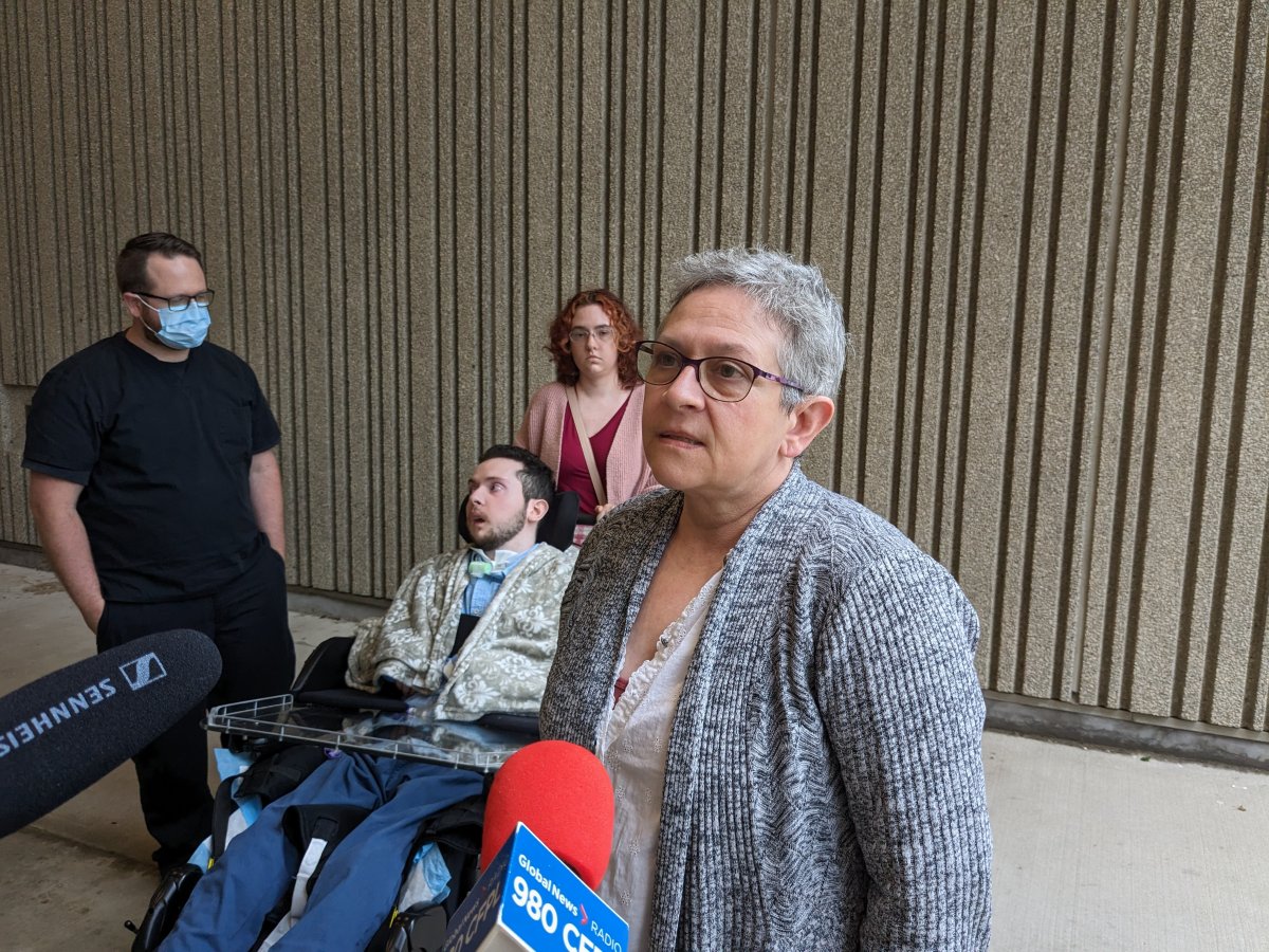 A woman speaks outside of court in front of her son, who is in a wheelchair, and a man and woman.