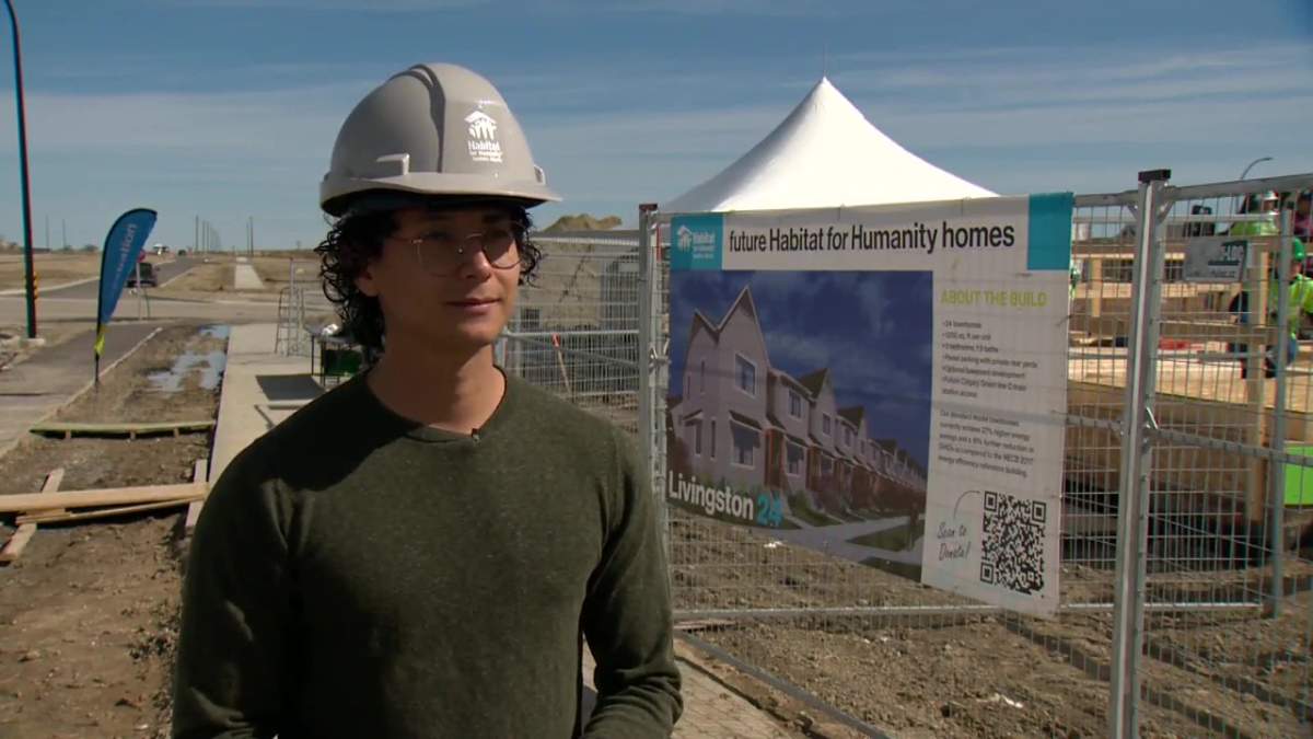 Santhiago Avila, who received a home through Habitat for Humanity, at construction of future affordable housing
