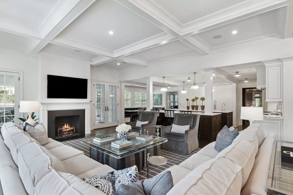 A white, open concept living room with a fireplace.