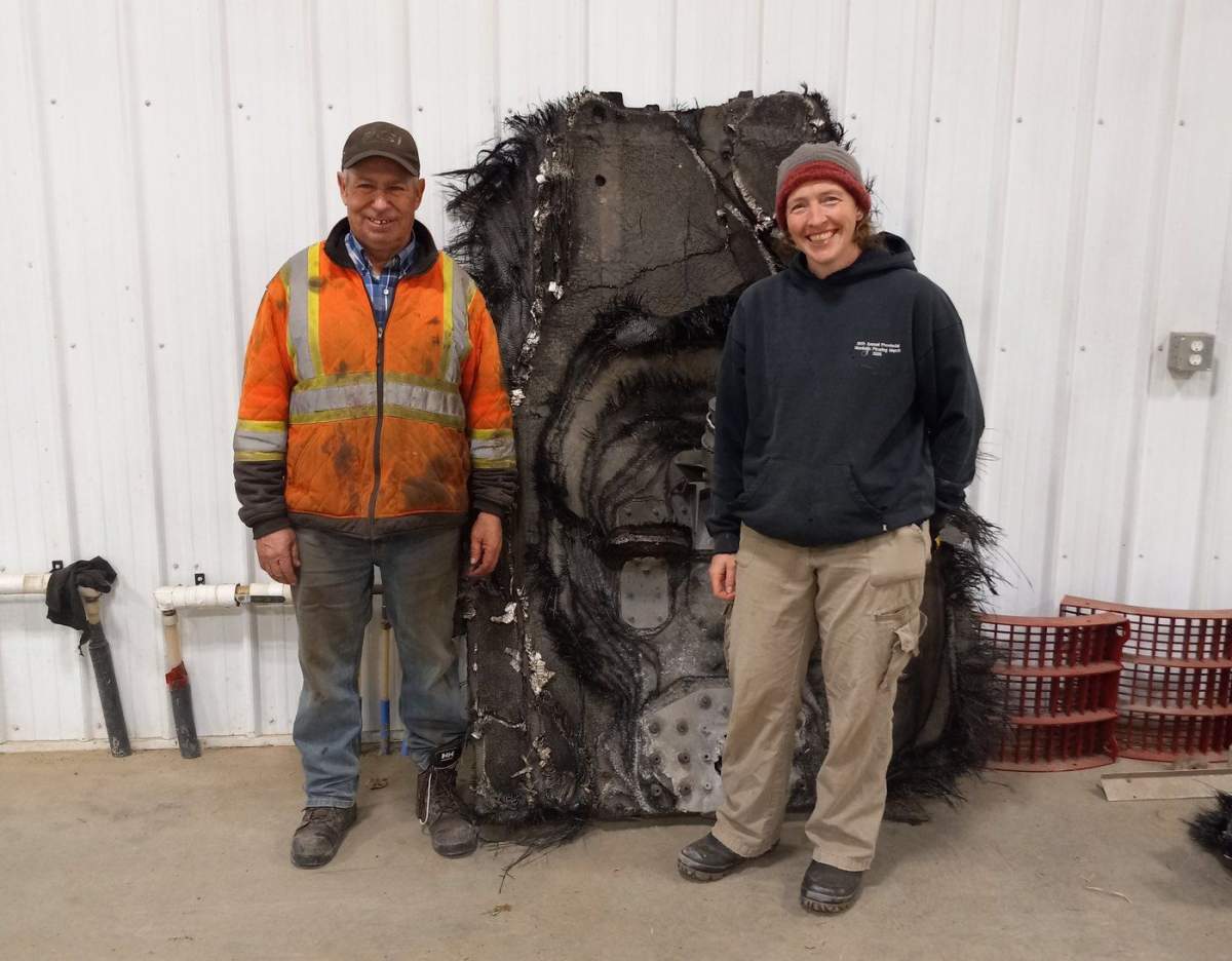 Barry Sawchuk (left) and Samantha Lawler, an associate professor of astronomy at the University of Regina, pose near a piece of space debris found on his farm in February. 