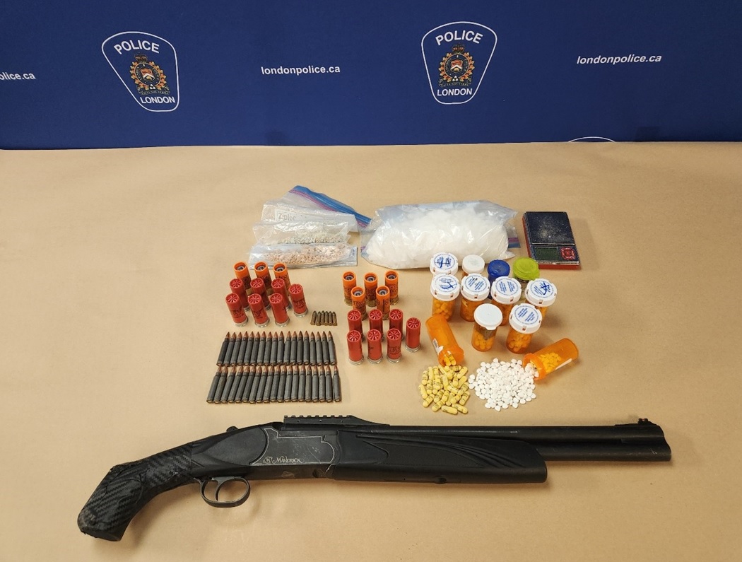 A shotgun, ammunition and drugs on a table.