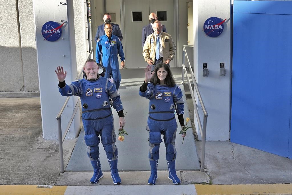 NASA astronauts Butch Wilmore, left, and Suni Williams wave to photographers after leaving the operations and checkout building for a trip to launch pad at Space Launch Complex 41 Wednesday, June 5, 2024, in Cape Canaveral, Fla