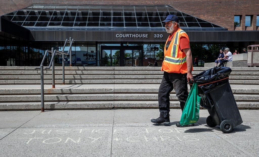 A jury is hearing evidence from two undercover officers in the trial of two men charged with conspiracy to commit murder at the 2022 border blockade at Coutts, Alta. A city employees walks over words of support chalked on the sidewalk outside the courthouse as the trial for two men charged with conspiracy to commit murder during the border protest at Coutts, Alta., gets underway in Lethbridge, Alta., Thursday, June 6, 2024.THE CANADIAN PRESS/Jeff McIntosh.