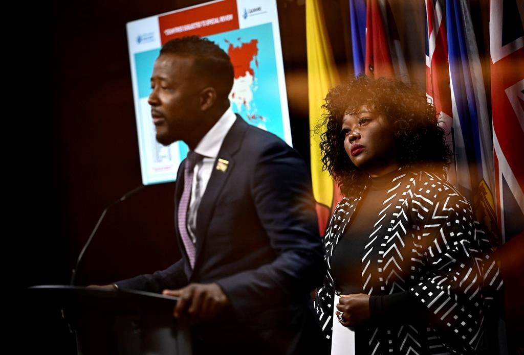 Bernadeth Betchi, CHRC employee and representative plaintiff, listens as Nicholas Marcus Thompson, executive director of the Black Class Action Secretariat, speaks at a news conference on the Global Alliance of National Human Rights Institutions' “Special Review” of the accreditation of the Canadian Human Rights Commission, on Parliament Hill, in Ottawa, Monday, June 10, 2024. 